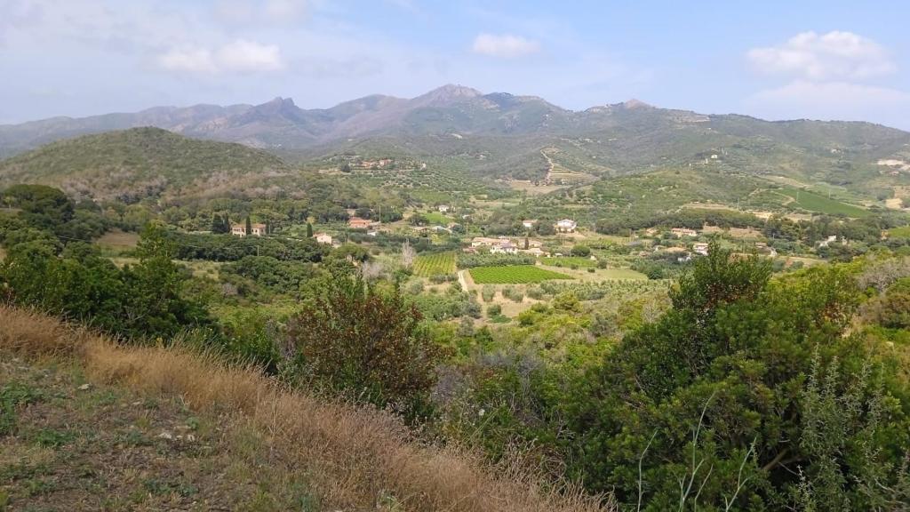 vistas a un valle con montañas en el fondo en Buen Retiro en Portoferraio