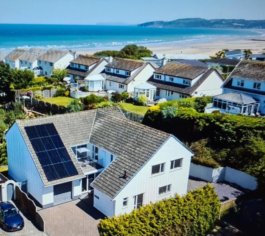 una casa con paneles solares en el techo en Benllech Beach, en Benllech