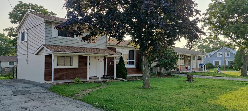 a white house with a tree in the yard at Lovely apartment house in Grimsby