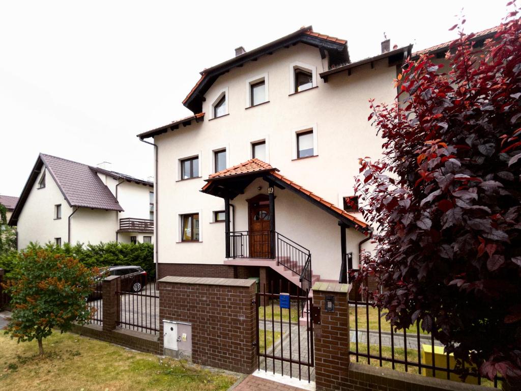 una gran casa blanca con una valla negra en Apartament Miłe Mieszkanko, en Władysławowo