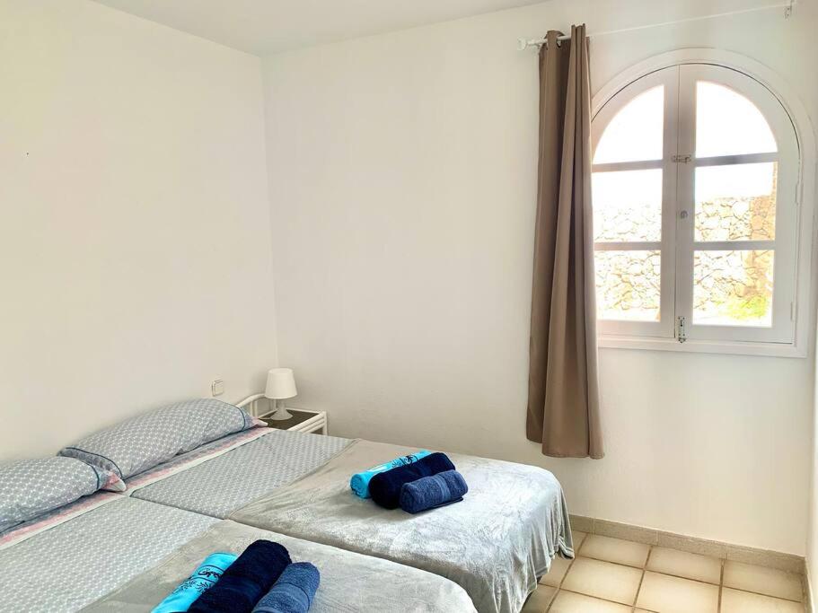 two beds in a bedroom with a window at Casa Gato in Corralejo