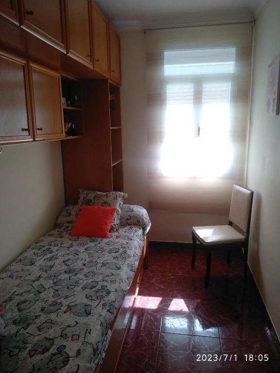 ein Schlafzimmer mit einem Bett, einem Stuhl und einem Fenster in der Unterkunft Casa con finca privada y gran aparcamiento in Cariño