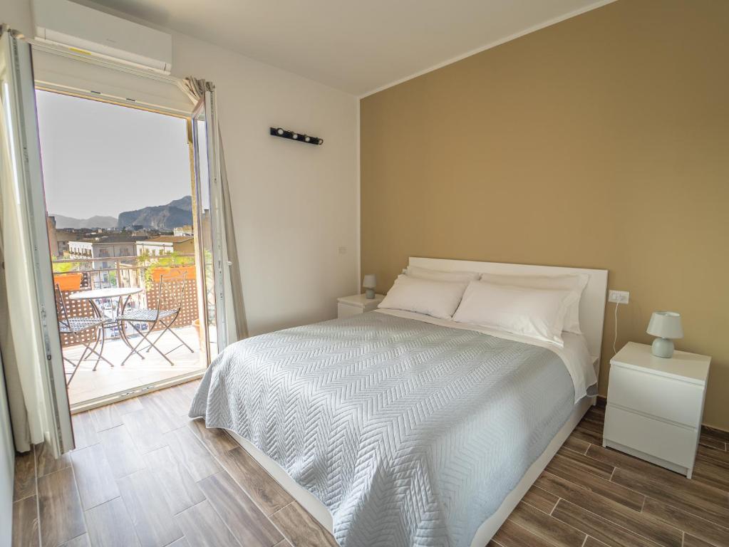a bedroom with a bed and a balcony with a table at Central Station Home - Fanale Rentals in Palermo