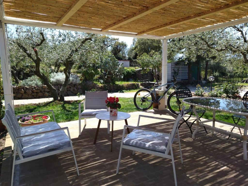 un patio con mesa, sillas y una bicicleta en B&B Valverde, en Dorgali