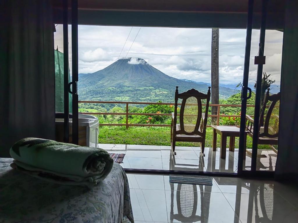 a room with a view of a mountain through a window at Encanto Arenal lodge in Fortuna