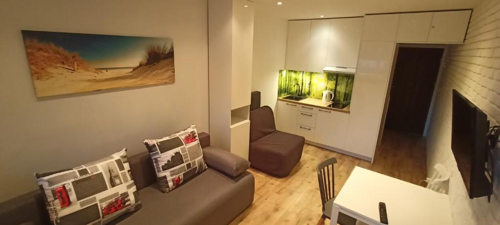 a living room with a couch and a fish tank at Blue Mare Apartamenty U Tomka in Łukęcin