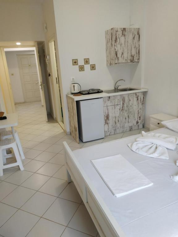 a white kitchen with a counter and a sink at Renia Studios in Agia Pelagia