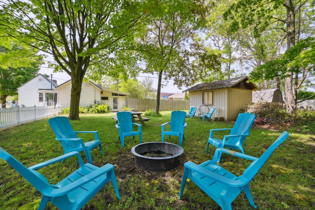 a group of blue chairs sitting around a fire pit at Boyne City Cottage Walk to Downtown and Lake! in Boyne City
