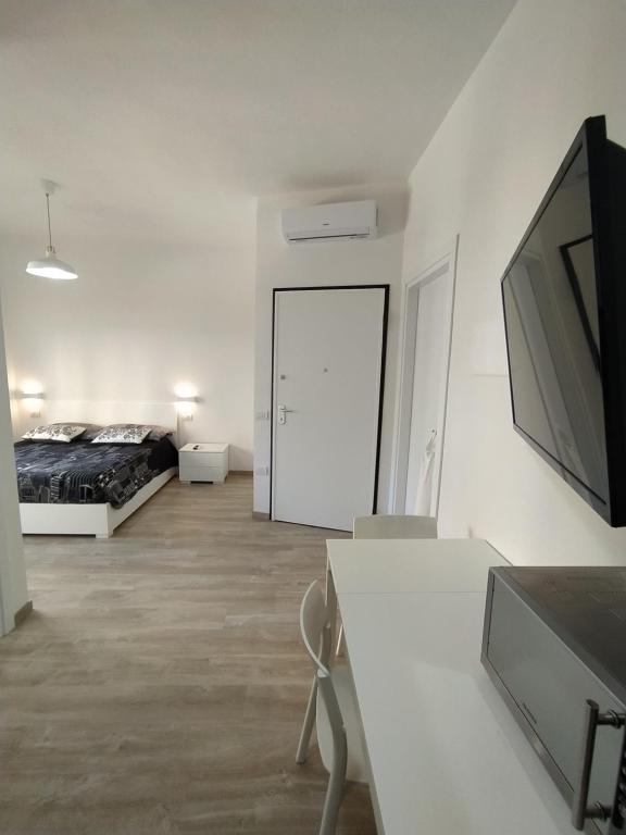 biały pokój z łóżkiem i telewizorem w obiekcie Town Center Apartment w Cagliari