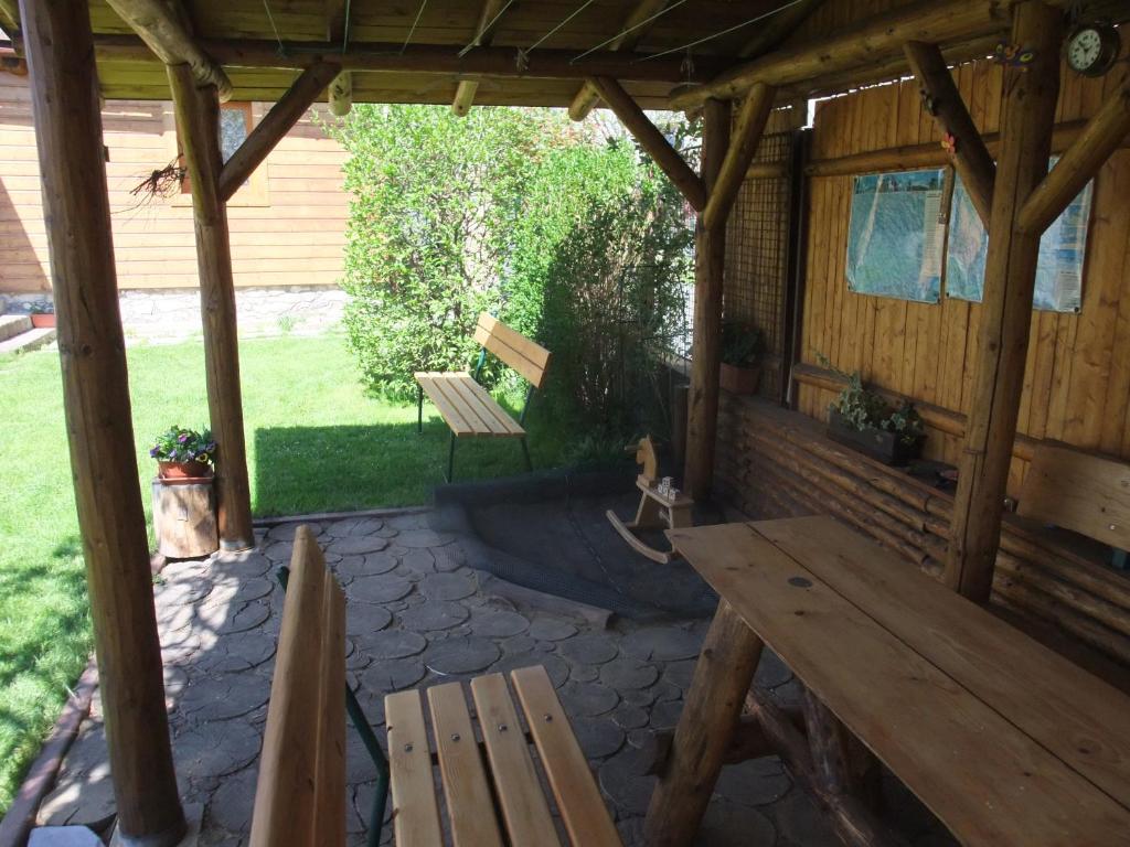 a wooden patio with a bench and a table at Apartmá V Oblouku in Jeseník