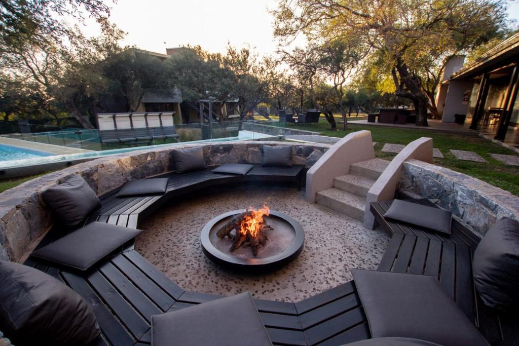 een vuurplaats in een tuin met stoelen en een bank bij A Hotel Decosuites in Merlo