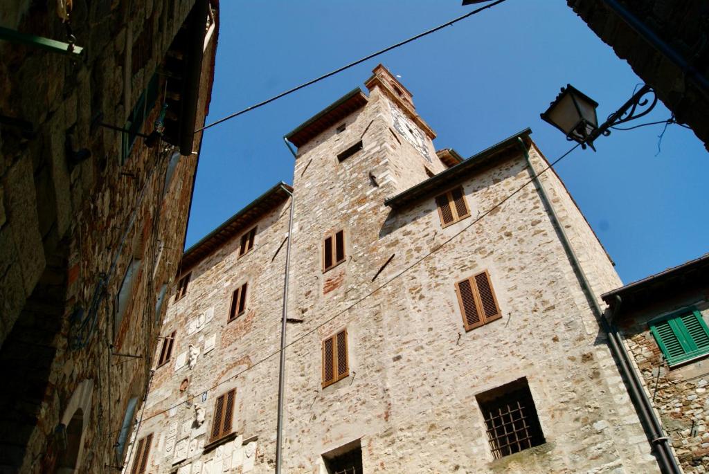 een groot stenen gebouw met een hoge toren bij L'appartamento sotto la Torre in Campiglia Marittima
