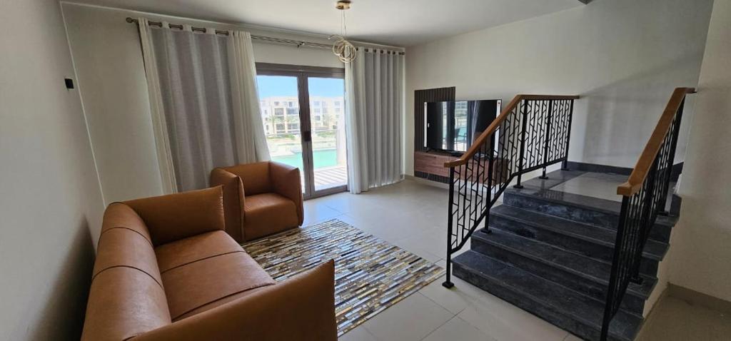 a living room with a couch and a stair case at Marina Marassi, North Coast in Sīdī ‘Abd ar Raḩmān