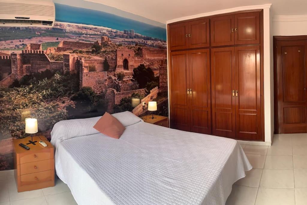 ein Schlafzimmer mit einem Bett und einem Wandbild in der Unterkunft Apartamento Castillo - Alquiler de temporada in Puerto de Sagunto