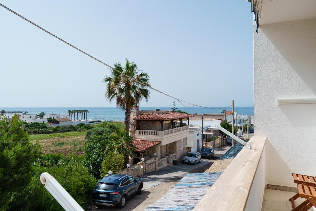 uma vista a partir da varanda de uma casa com uma palmeira em VistaMare Paradiso em Torre Vado