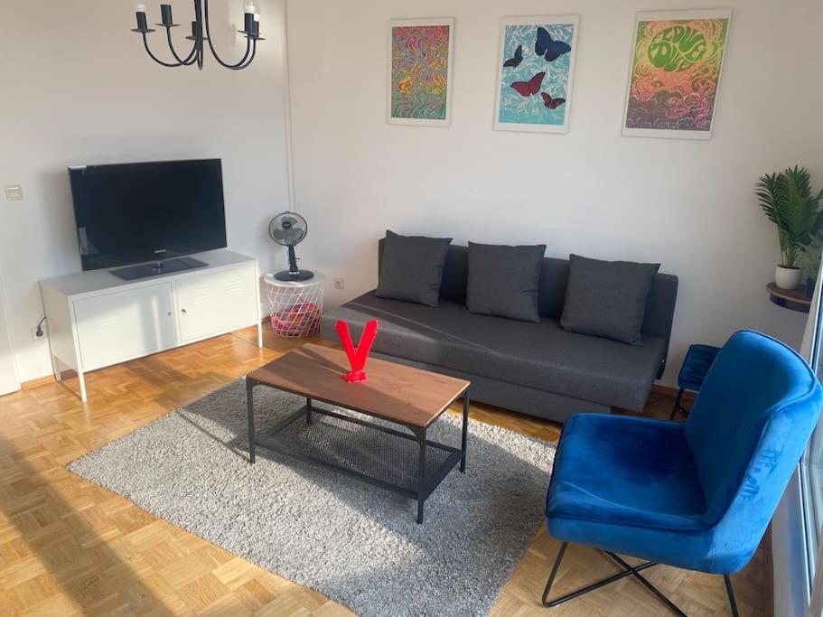 a living room with a couch and a table and a blue chair at Schöne, helle Wohnung im Zentrum in Münster