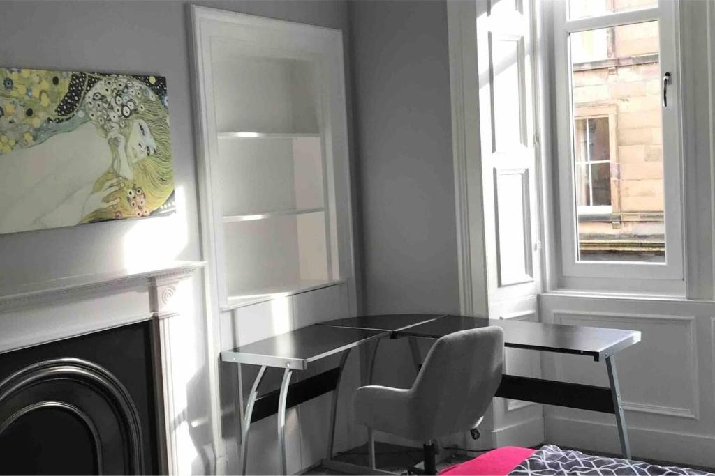 um quarto com uma mesa, uma cadeira e uma janela em Grange Lone entire apartment with two double beds em Edimburgo