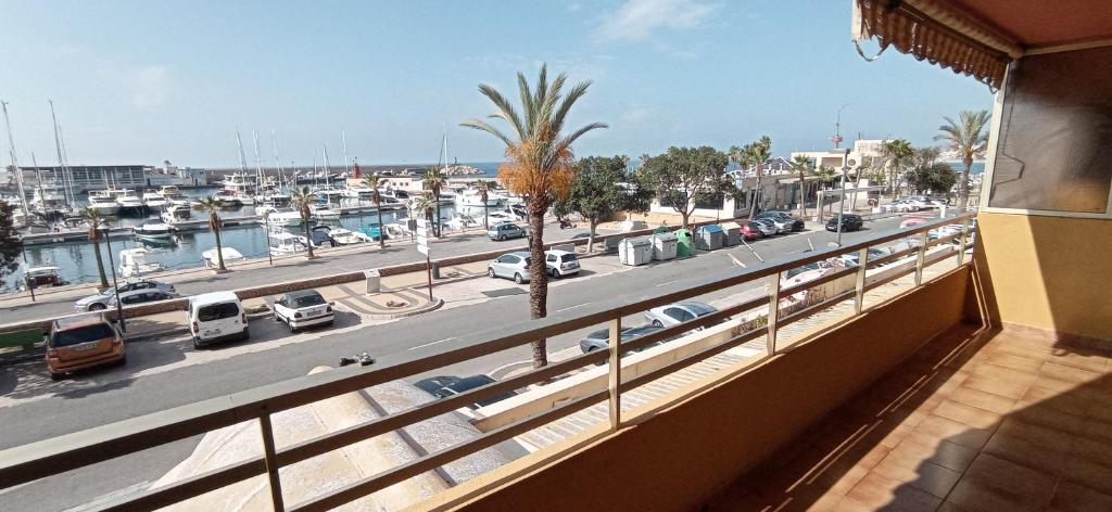 un balcón con vistas a un puerto deportivo con coches aparcados en Apartamento Frente al club Nautico, soleado y en primera linea de playa, en Villajoyosa