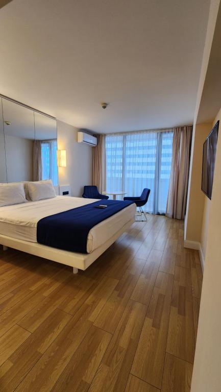 um quarto com uma cama grande e uma janela grande em Sea Breeze Studio, Orbi City, block A em Batumi