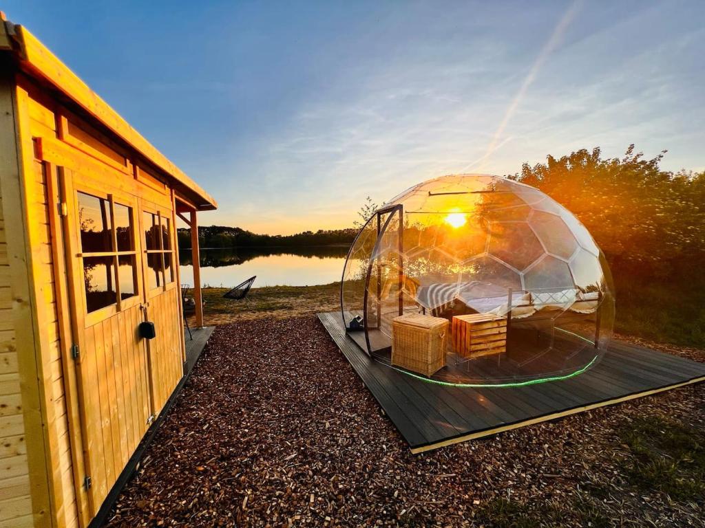 a dome tent with baskets on a table next to a building at Beheiztes Bubble Tent am See - Sternenhimmel in Wadersloh