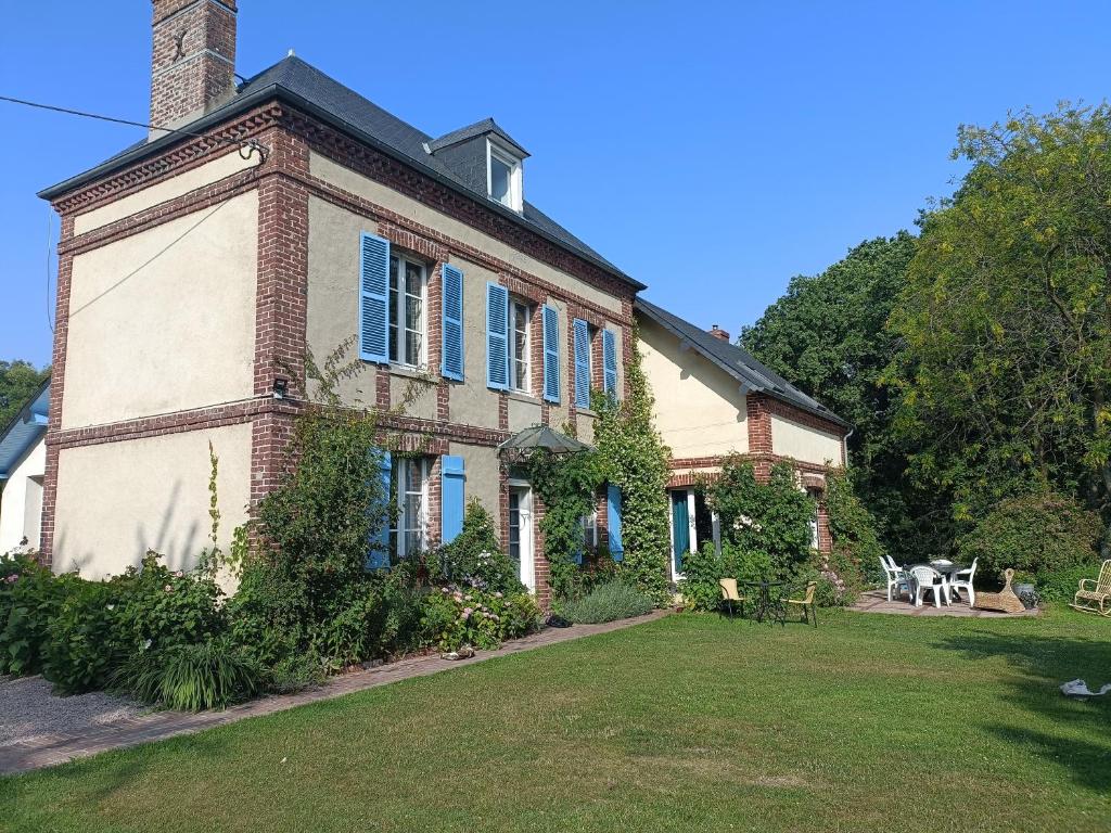 an old brick house with blue windows and a lawn at La mare aux petits diables in Équemauville