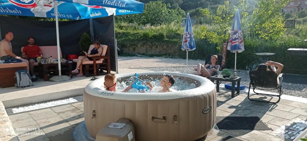a group of people sitting in a hot tub at Apartman Mira i Denis in Rab