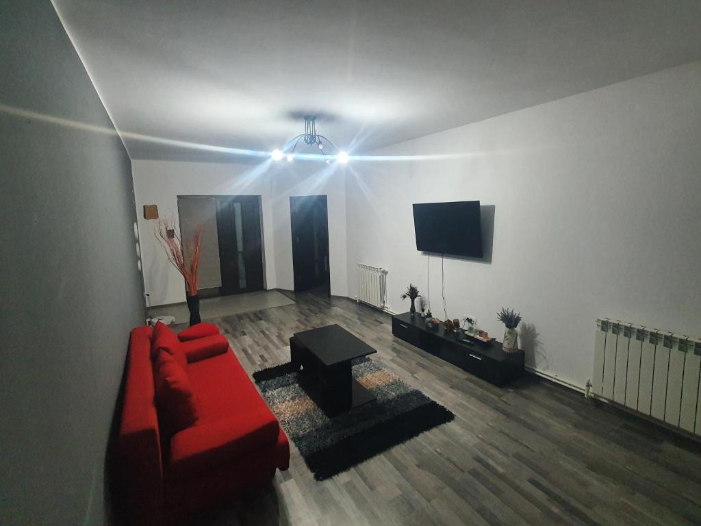 エフォリエ・ノルドにあるCasa Alexia Eforie Nordのリビングルーム(赤いソファ、テレビ付)