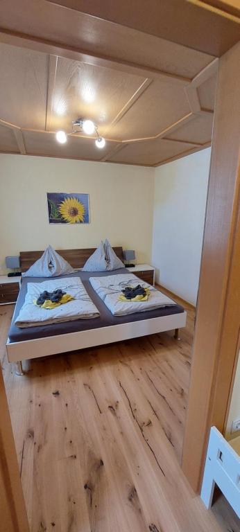 1 dormitorio con 1 cama y suelo de madera en Appartements Haus Bergland, en Sankt Martin am Tennengebirge