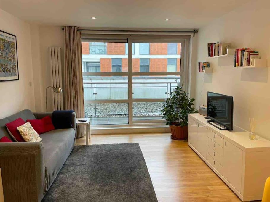 a living room with a couch and a television at Central London apartment in London