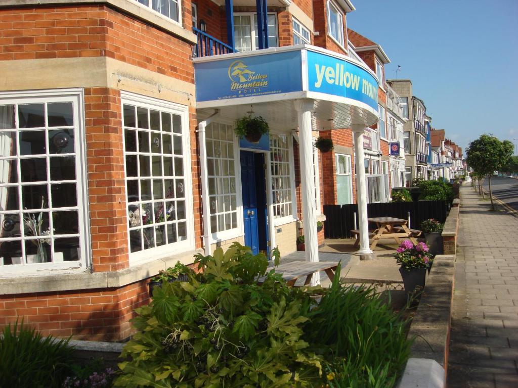 a brick building with a blue sign on the front of it at Yellow Mountain Hotel in Skegness