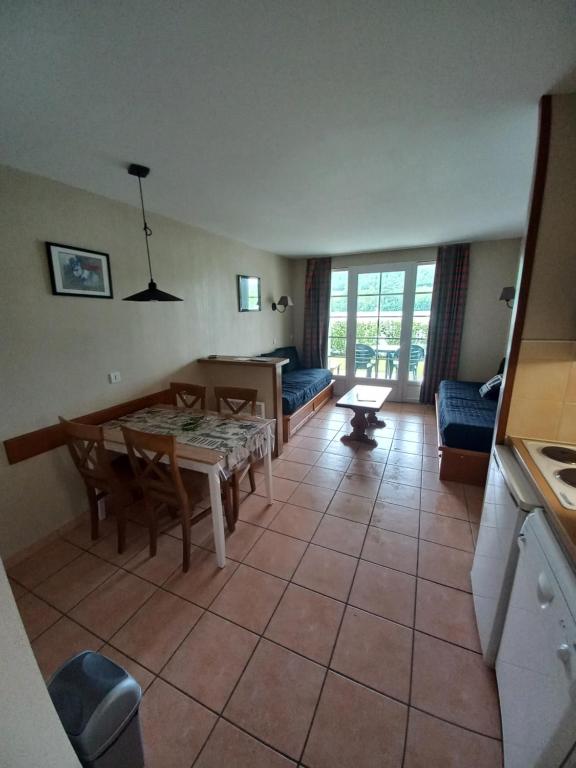 une cuisine et un salon avec une table et des chaises dans l'établissement appartement au bord du lac, à Marciac