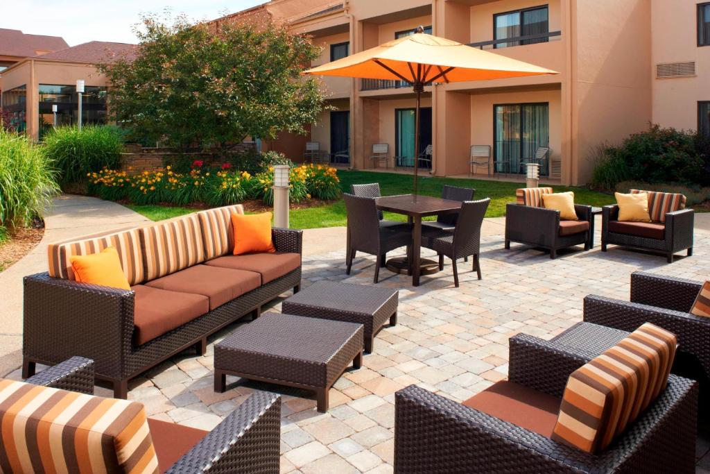 a patio with couches and tables and an umbrella at Courtyard by Marriott Rockford in Rockford
