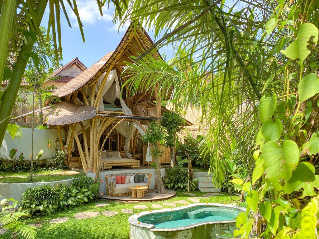 a resort with a swimming pool in front of a house at Wahem Eco Bamboo in Ubud