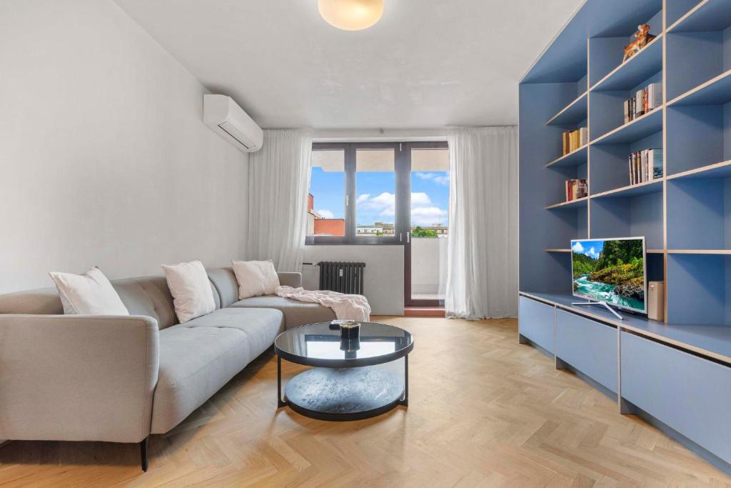 a living room with a couch and a tv at Elegant City Escape - Modern & Central in Bratislava