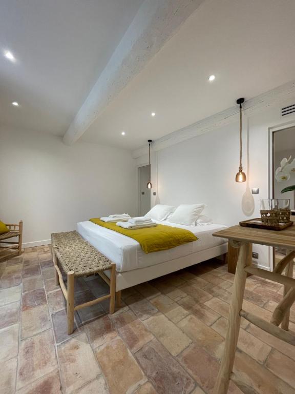 a bedroom with a large bed and a table at MAS MILLÉSIME - Chambre double - petit déjeuner - piscine - Mas du XVIIIème siècle proche Saint-Rémy-de-Provence in Mas blanc des Alpilles