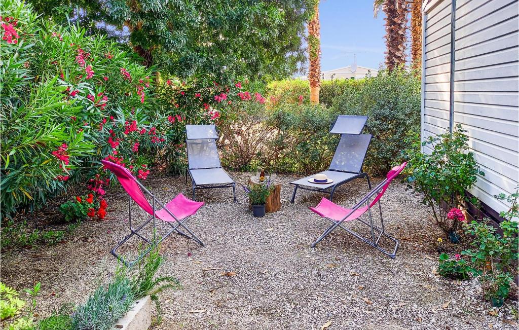 a group of chairs sitting in a garden at Stunning Caravan In Hyres With Wifi And 3 Bedrooms in Hyères