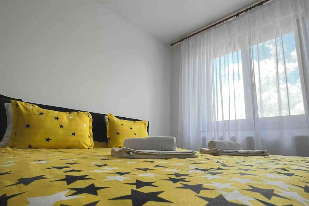 a bedroom with a large bed with yellow pillows at Alex 2 Apartament in Iaşi