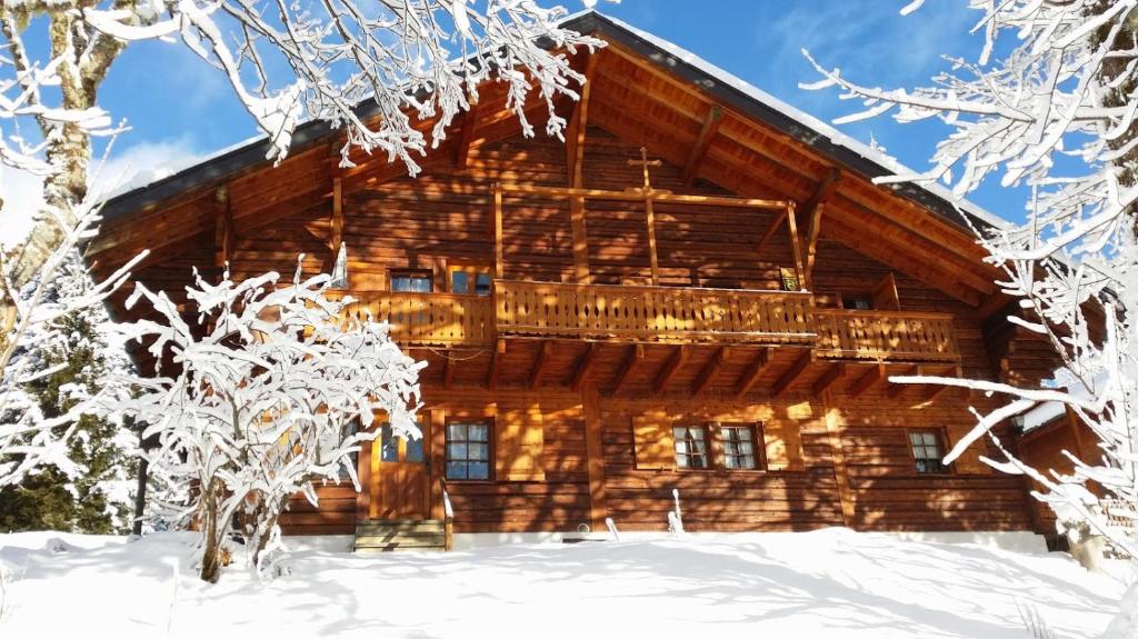 une cabane en rondins dans la neige avec des arbres enneigés dans l'établissement Appartement - dans le chalet Carmazin, à Morgins