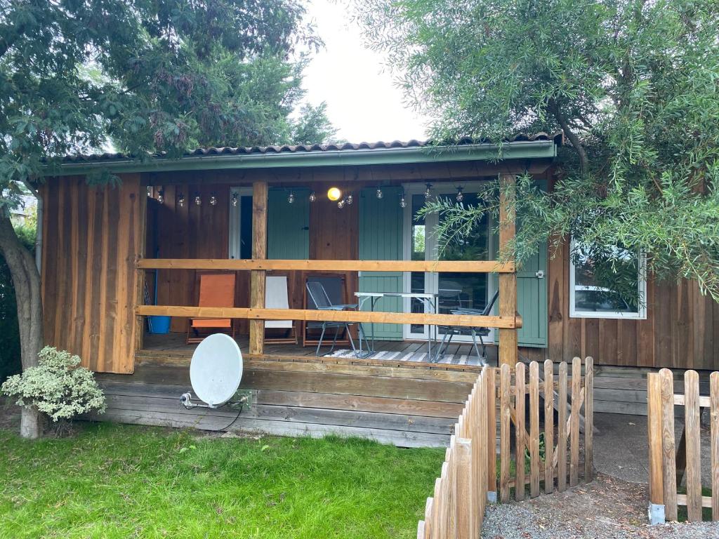 une petite cabine avec une table et des chaises dans la cour dans l'établissement Le chalet Arcachonais, à La Teste-de-Buch