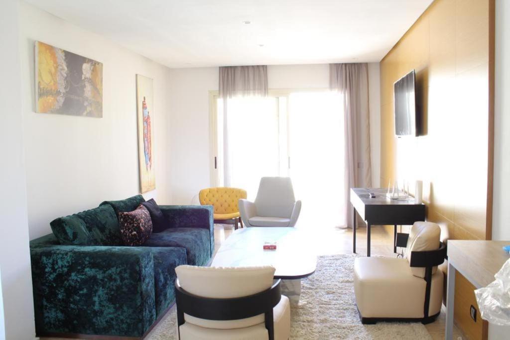 uma sala de estar com um sofá e uma mesa em Appt 22 Bloc G- Hicherraton plage Residence Bella Vista, BOUZNIKA BAY em Skhirat