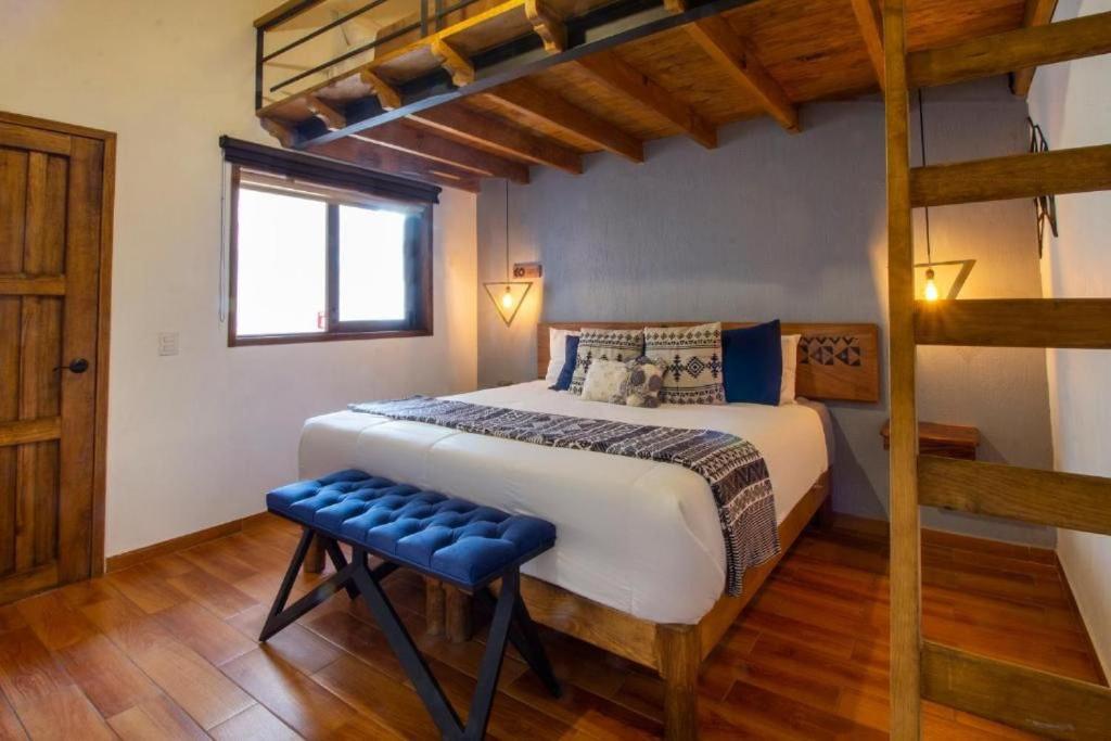 - une chambre avec un grand lit et du parquet dans l'établissement Hotel Kali, à Tapalpa