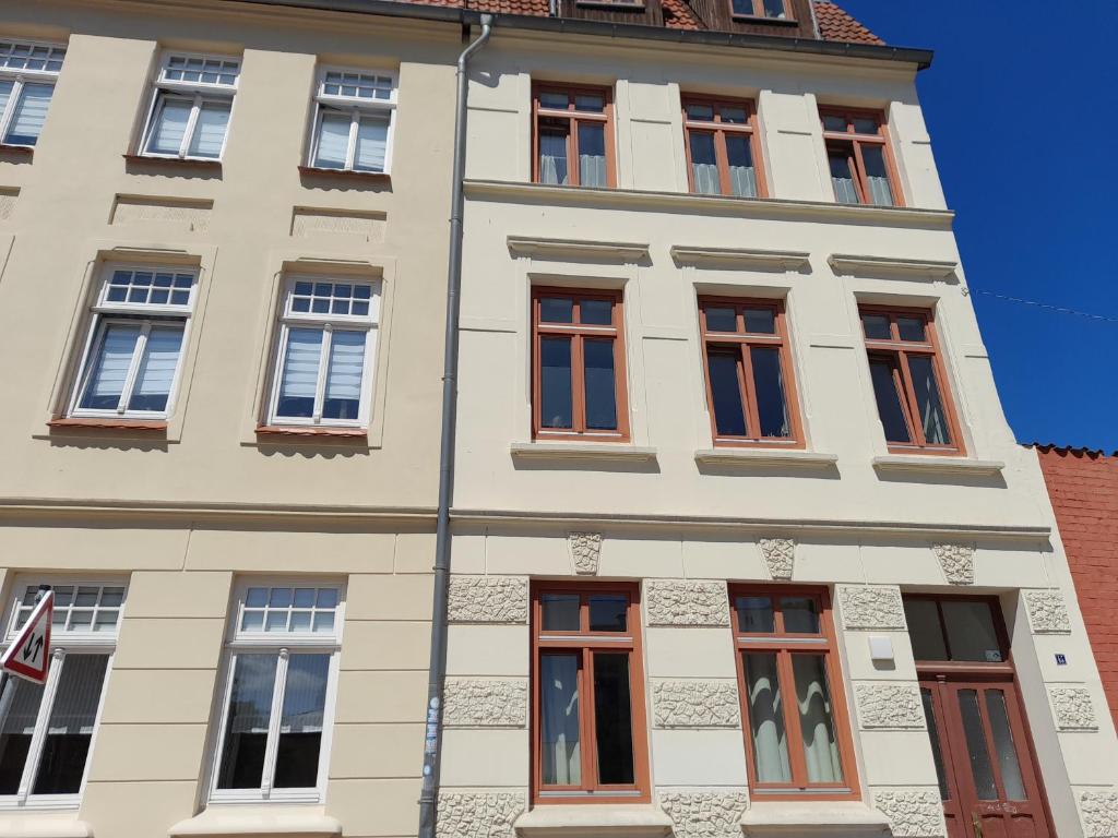 Un grand bâtiment blanc avec de nombreuses fenêtres dans l'établissement Kleine Altstadt-Wohnung mit Terrasse, à Wismar