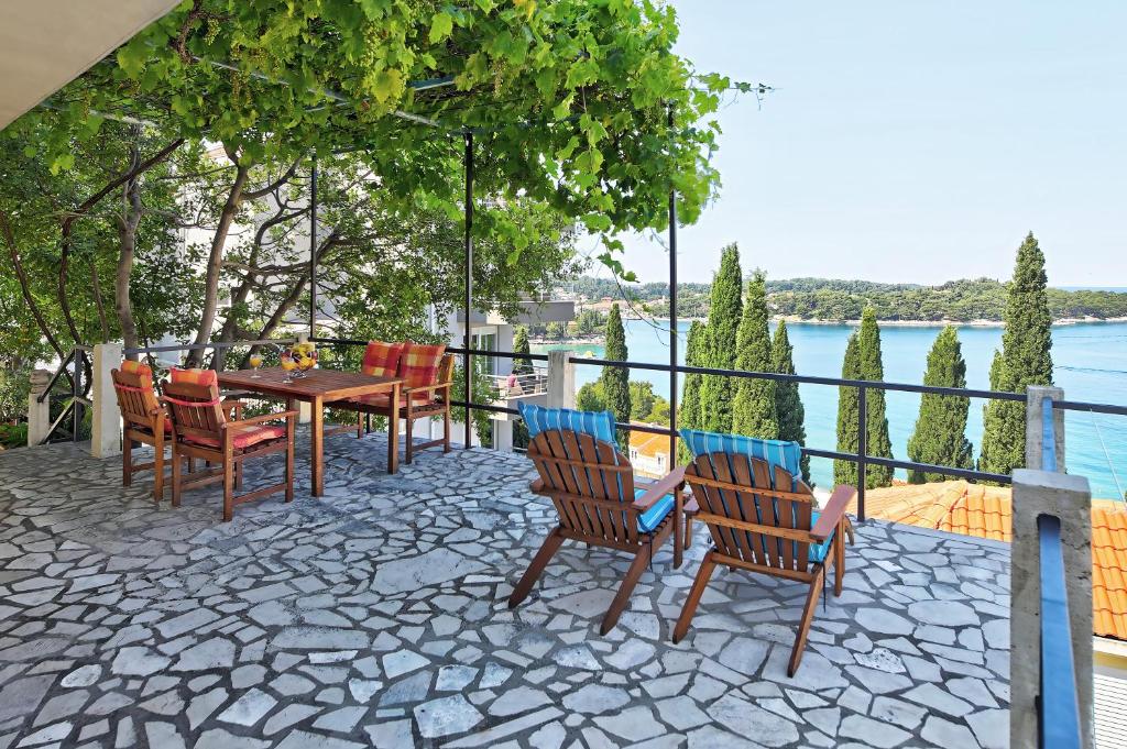 a patio with chairs and a table with a view of the water at Bojana Apartments in Cavtat