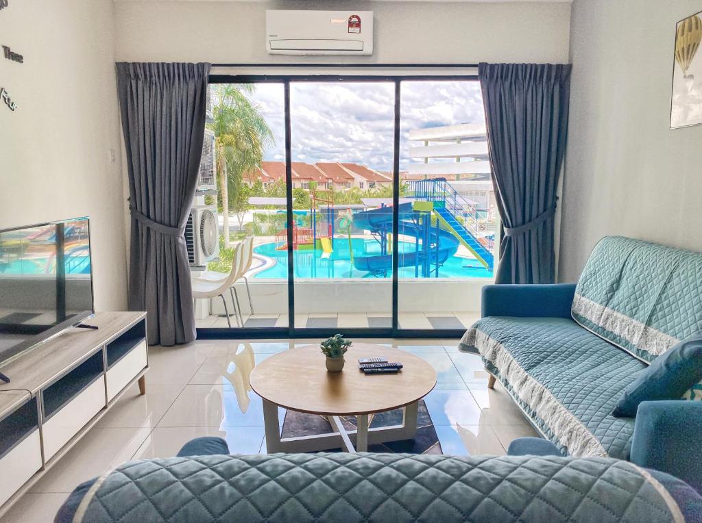 a living room with a couch and a table at Cozy Suite Pool View@Ipoh Waterpark FREE (WI-FI)&Netflix Station 18 pengkalan Manhattan in Ipoh