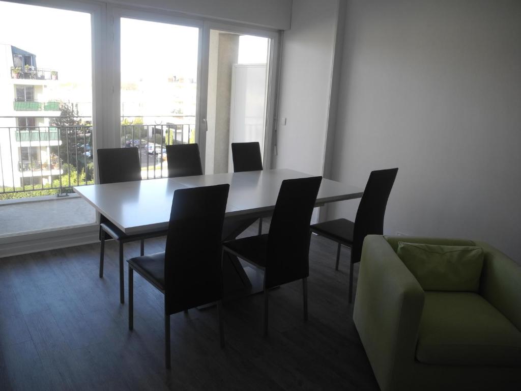 una sala da pranzo con tavolo, sedie e una finestra di Apt Standing Bordeaux Chartrons a Bordeaux