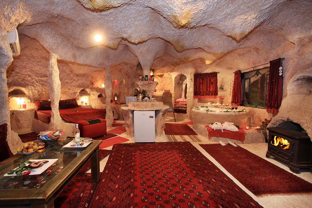 una habitación en una cueva con chimenea en אלאדין בקתות ומערות - נופש כפרי קסום ליד הכנרת עם מקלט צמוד, en Had Nes