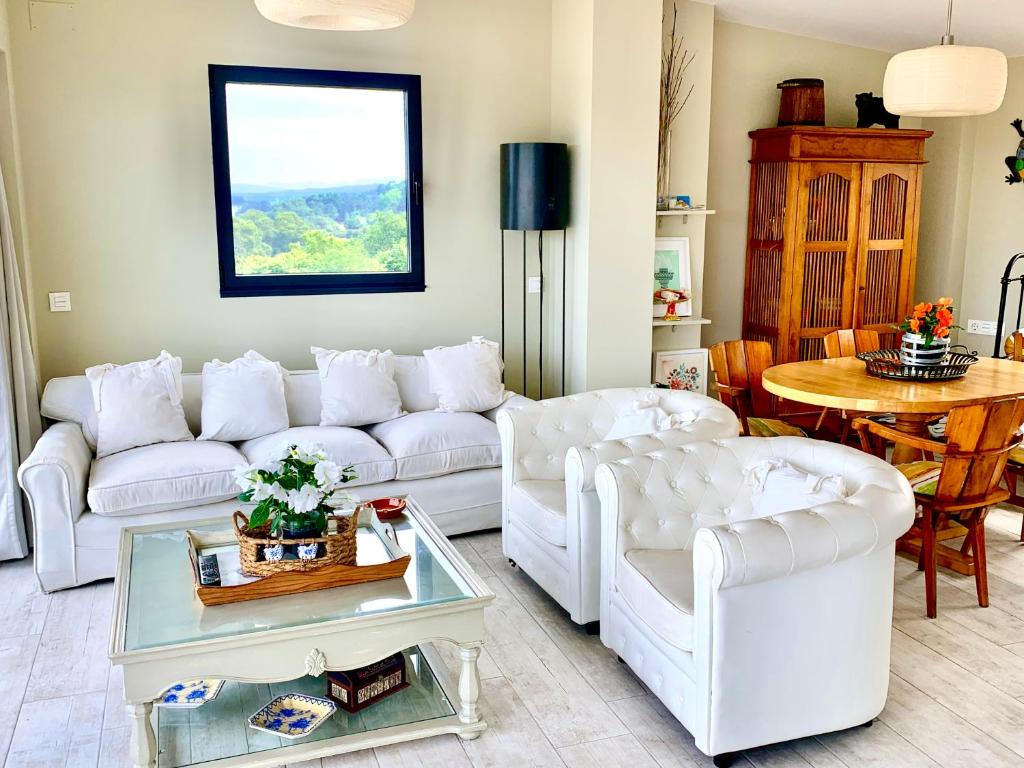 una sala de estar con sofás blancos y una mesa. en Breathtaking views to Ría de Arosa, en Vilagarcía de Arousa