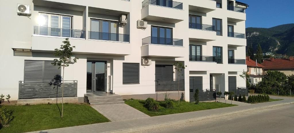 a large white building on the side of a street at Apartman Reina in Soko Banja