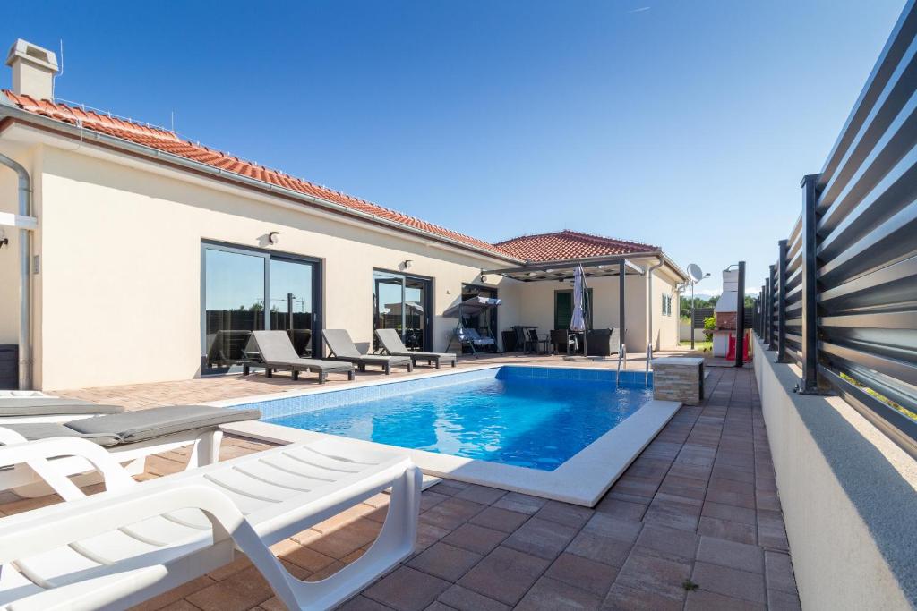 Villa con piscina y tumbonas en Luxury villa with pool near the beach 2, en Vrsi
