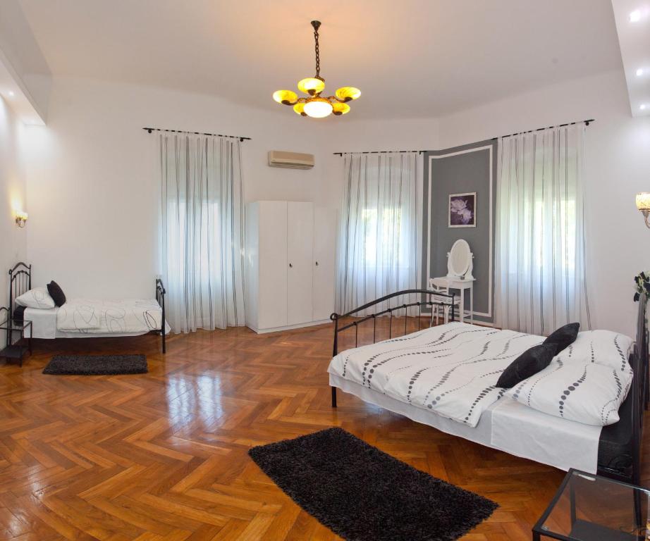 a bedroom with a bed and a chandelier at Villa Barbara in Split